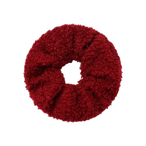 roodkleurige scrunchie (elastiek met stof er om heen) met een zachte teddy stof, afgebeeld op een witte achtergrond