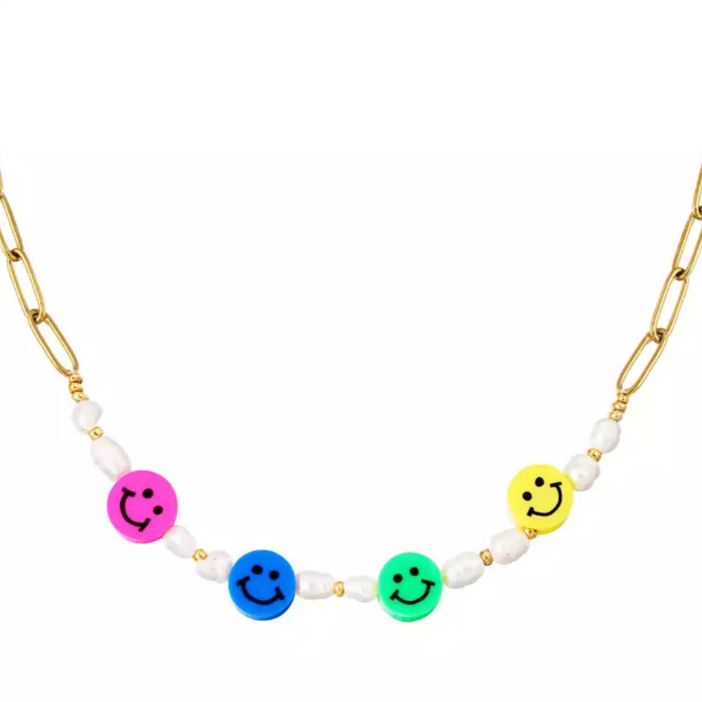 Goudkleurige roestvrijstalen ketting met grote schakels en parels en gekleurde smileys, de ketting is afgebeeld voor een witte achtergrond.