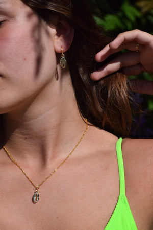 model met goude schelp oorbellen en ketting